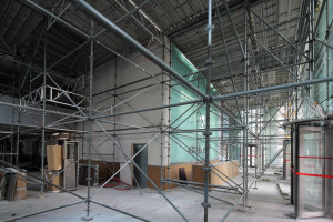 La tour avait cette particularité d’être entourée d’une ceinture béton. Construite sans parvis, persoe ne savait où se situait l’entrée, l’accès pouvant se faire sur trois côtés. Le hall a été complètement rénové sur une triple hauteur (RC jusqu’au 2e étage) ; la ceinture béton entre les piliers a été sciée (en blocs manu-portables !) pour faire largement entrer la lumière naturelle et créer un vaste hall d’entrée. © Nicolas Vercellino 